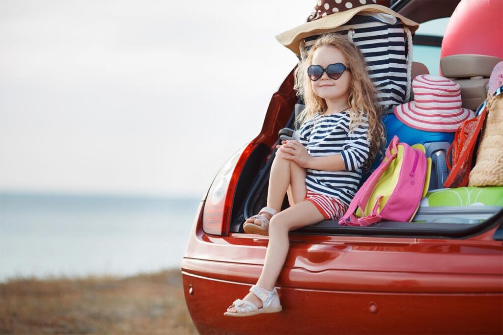 A child sitting in the trunk of a car