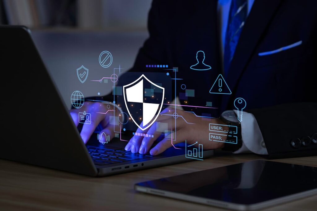A man a typing on a laptop with cyber security icons
