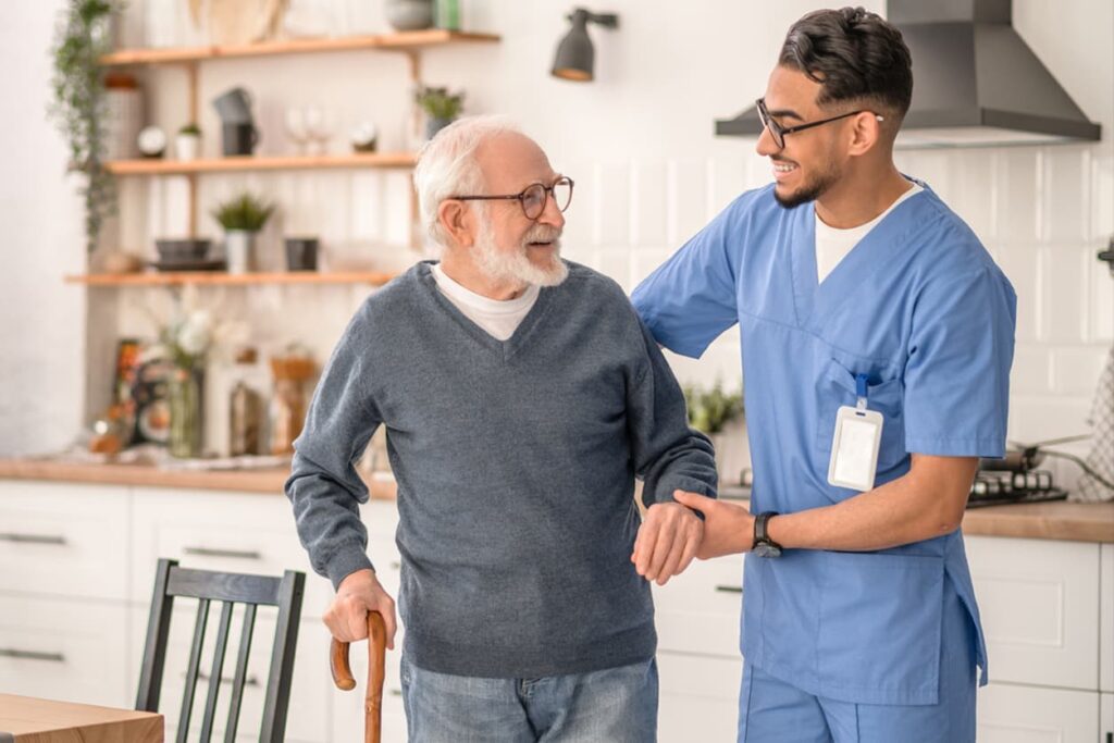 Medical worker helping his patient to move around the apartment