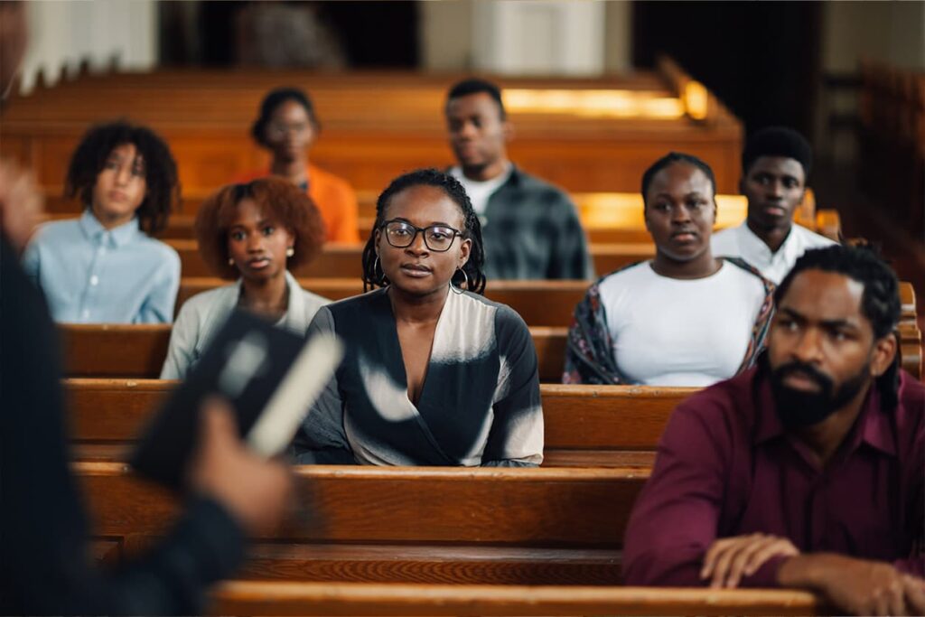 Several people sitting on church pews